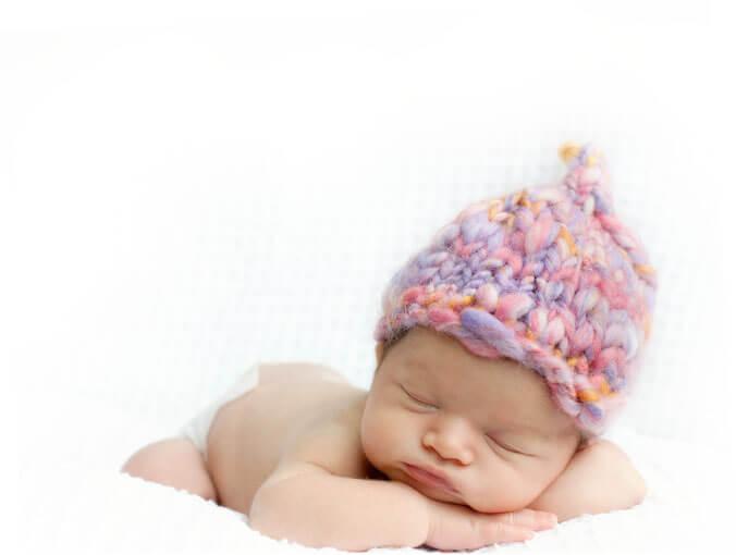 sleeping newborn baby with pink hat